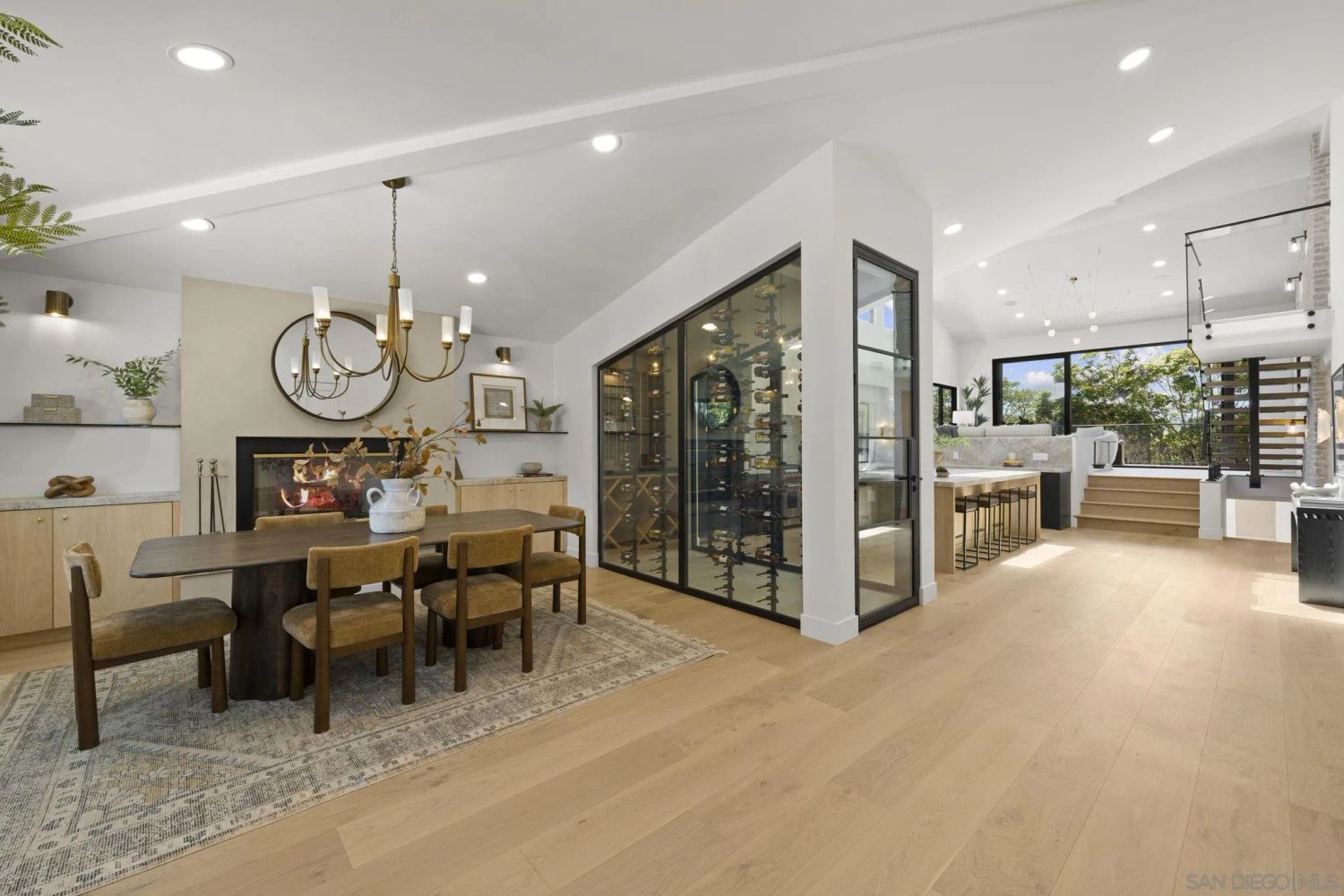 Open-plan Del Mar interior with dining area, wine room, and kitchen.
